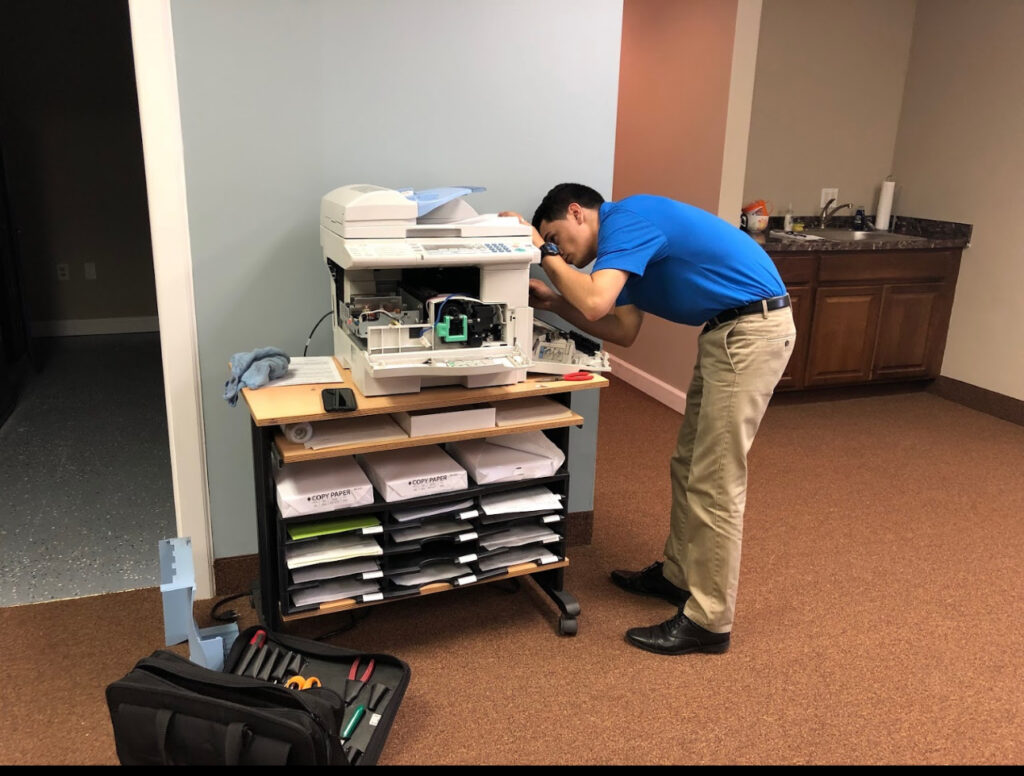 Printer technician fixing a printer